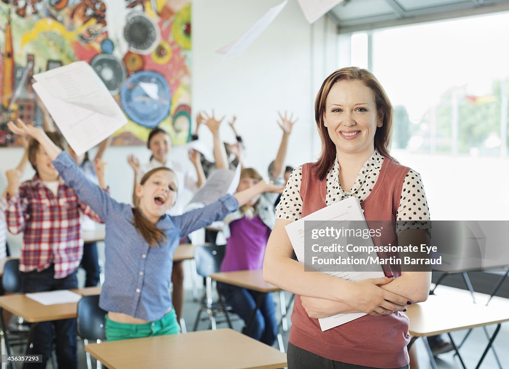 Teacher with celebrating students in classroom