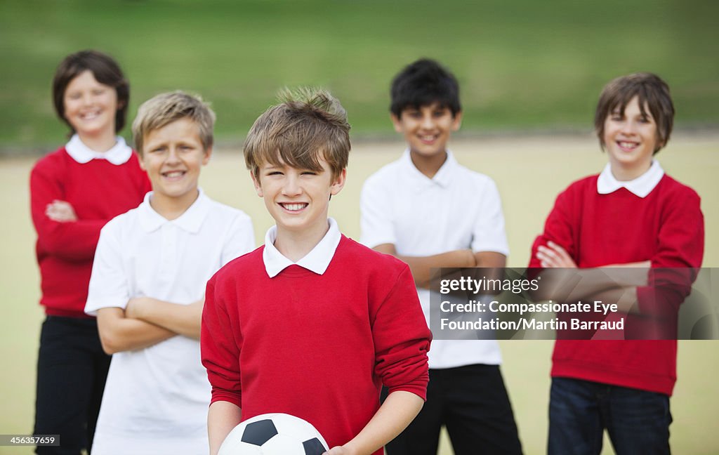 Portrait of smiling boys (10-11) with soccer ball