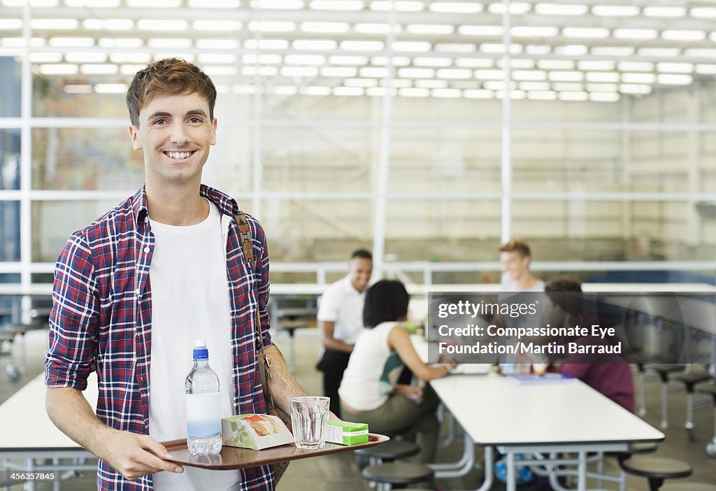 Smiling college student in cafeteria with food