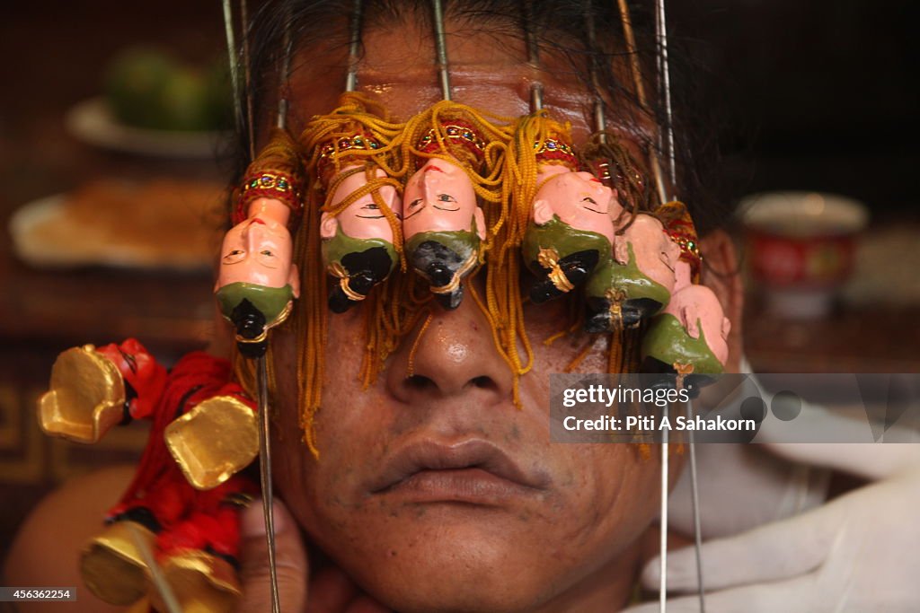 A follower of the Chinese Jui Tui Shrine, pierces his face...