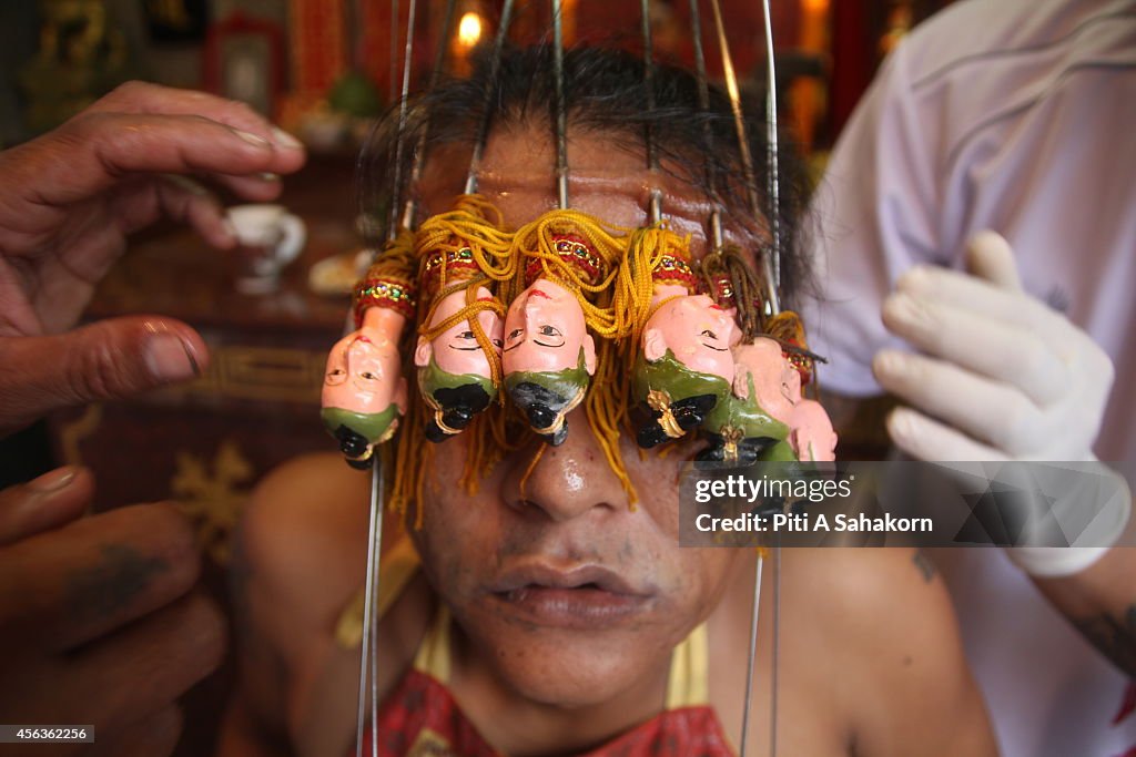 A follower of the Chinese Jui Tui Shrine, pierces his face...