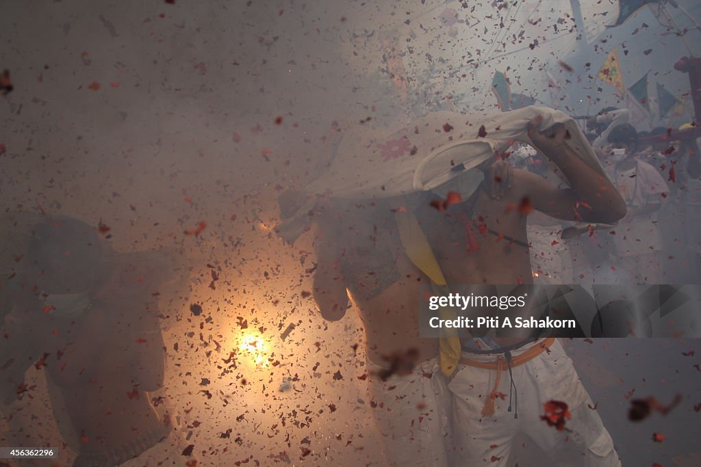 Firecrackers explode over devotees of a Chinese shrine...
