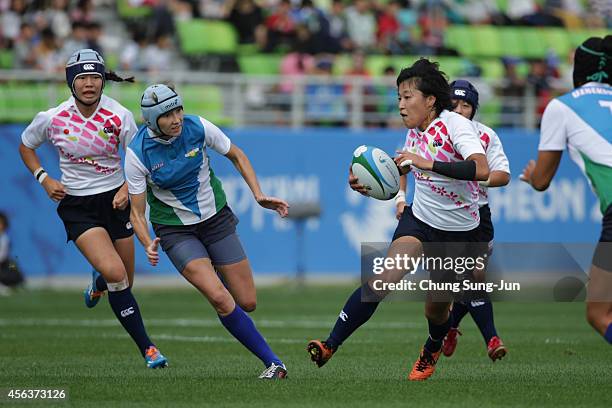 Yusaku Kuwazuru of Japan competes with Umida Saribaeva of Uzbekistan in the Women's Preliminary Round - Group A during day eleven of the 2014 Asian...