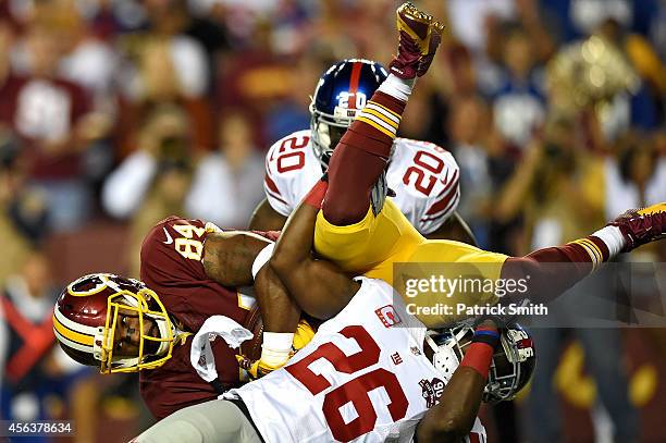 Tight end Niles Paul of the Washington Redskins is tackled by strong safety Antrel Rolle of the New York Giants in the first half at FedExField on...