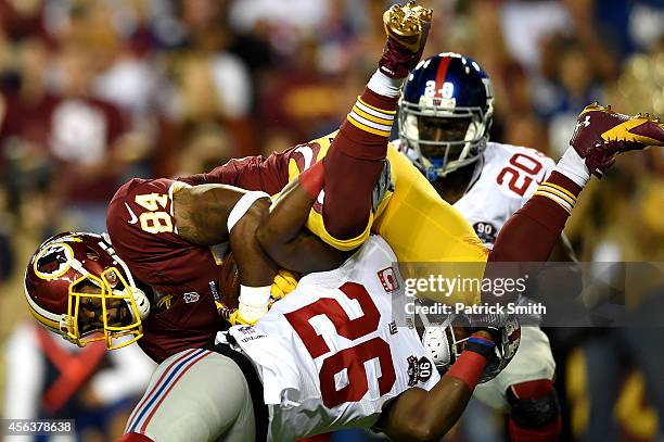 Tight end Niles Paul of the Washington Redskins is tackled by strong safety Antrel Rolle of the New York Giants in the first half at FedExField on...