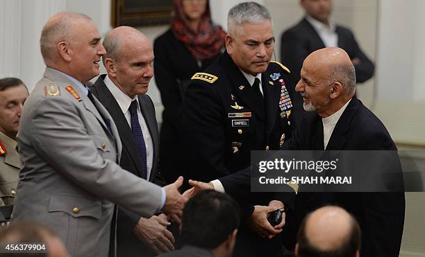 Afghan President Ashraf Ghan shakes hands with deputy commander of the NATO-led International Security Assistance Force German Army Lt. General...