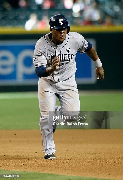 Rymer Liriano of the San Diego Padres hustles back to first base to avoid being doubled up on a deep fly ball during the seventh inning of a MLB game...