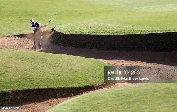 Darren Clarke of Northern Ireland plays out from a bunker of the third hole during the practice round prior to the 2014 Alfred Dunhill Links...
