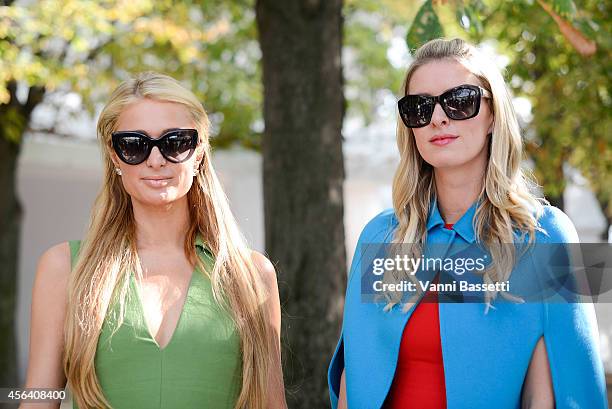 Paris and Niki Hilton pose wearing Valentino after the Valentino show on September 30, 2014 in Paris, France.