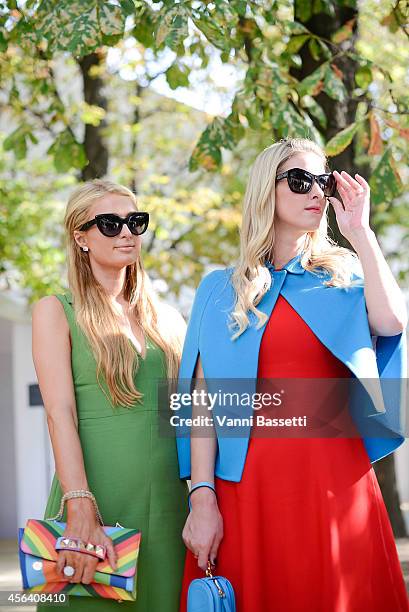 Paris and Niki Hilton pose wearing Valentino after the Valentino show on September 30, 2014 in Paris, France.