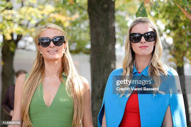 Paris and Niki Hilton pose wearing Valentino after the Valentino show on September 30, 2014 in Paris, France.