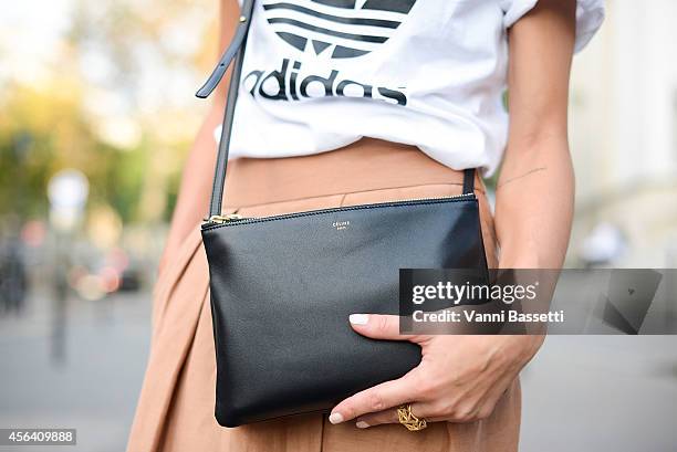 Fashion blogger Ilenia Toma poses wearing Adidas t-shirt, Mango pants and Celine bag on September 30, 2014 in Paris, France.