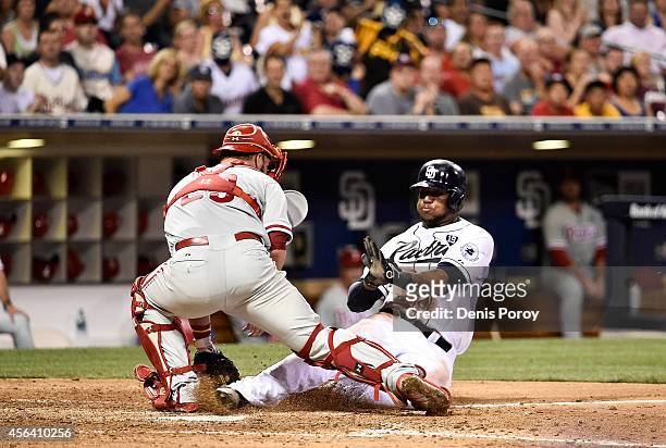 Rymer Liriano of the San Diego Padres scores ahead of the tag of Cameron Rupp of the Philadelphia Phillies during the sixth inning of a baseball game...