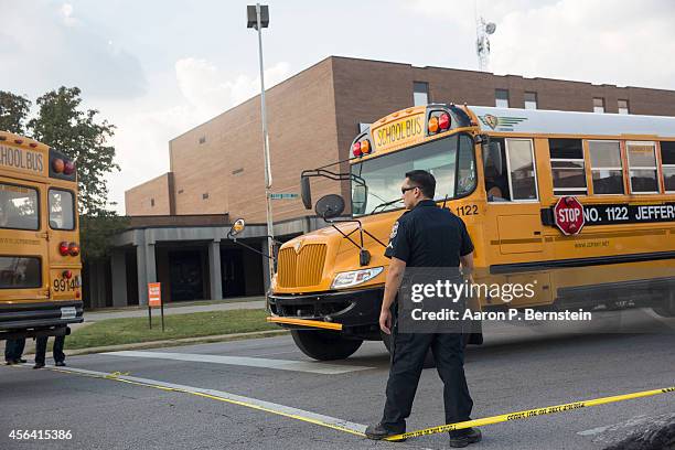Police officers allow a school bus to depart Fern Creek High School following a shooting incident September 30, 2014 in Louisville, Kentucky. Police...