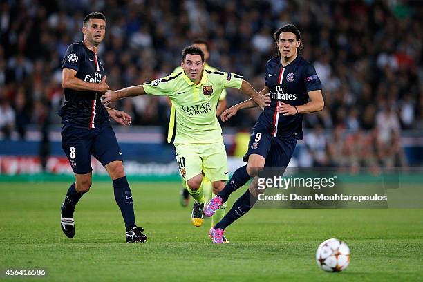 Thiago Motta and Edinson Cavani of PSG stop the attack from Lionel Messi of Barcelona during the Group F UEFA Champions League match between Paris...