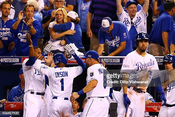 Jarrod Dyson of the Kansas City Royals celebrates with teammates after scoring on a sacrafice fly by Norichika Aoki in the ninth inning to tie the...