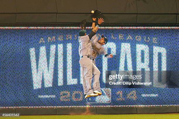 Jonny Gomes and Sam Fuld of the Oakland Athletics collide on a triple hit by Eric Hosmer of the Kansas City Royals in the 12th inning during the...