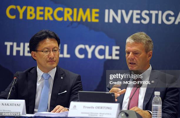 Assistant Director Head of EC3 Europol Troels Oerting speaks next to Executive Director of Interpol Global Complex for Innovation Noboru Nakatani...