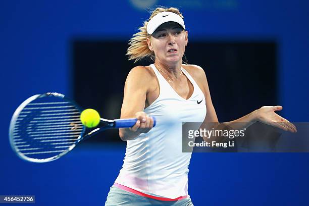 Maria Sharapova of Russia returns a shot against Carla Suarez Navarro of Spain during day five of the China Open at the China National Tennis Center...