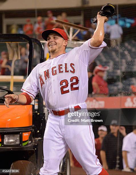 Tony Campana of the Los Angeles Angels of Anaheim throws his glove at a teammate after being doused in water after the game against the Seattle...