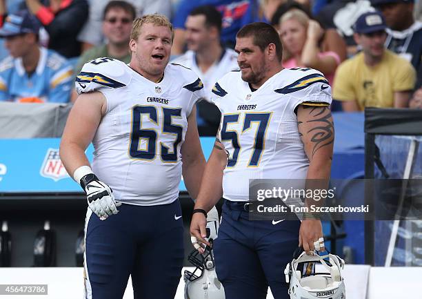 Chris Watt of the San Diego Chargers talks to Doug Legursky on the sideline during NFL game action against the Buffalo Bills at Ralph Wilson Stadium...