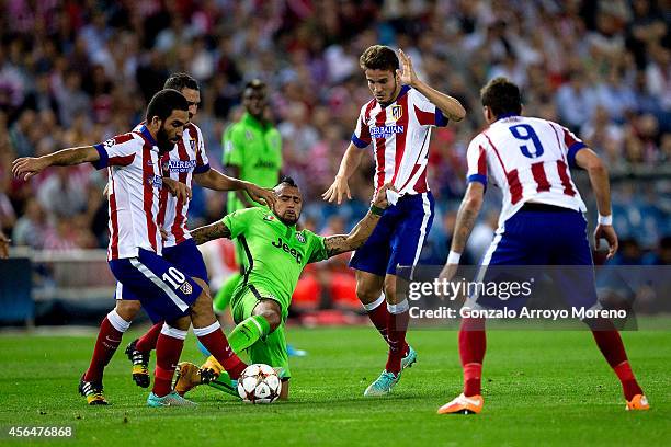 Arturo Vidal of Juventus competes for the ball with between Cristian Ansaldi and Arda Turan of Atletico de Madrid during the UEFA Champions League...