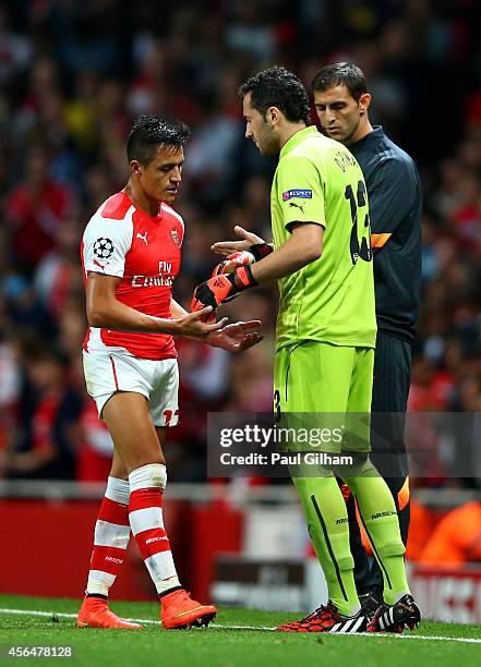 Alexis Sanchez of Arsenal taps hands with David Ospina as he is substituted following Wojciech Szczesny's red card during the UEFA Champions League...