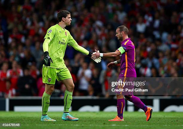 Wojciech Szczesny of Arsenal taps hands with Wesley Sneijder of Galatasaray AS as he walks off the pitch after receiving a red card during the UEFA...