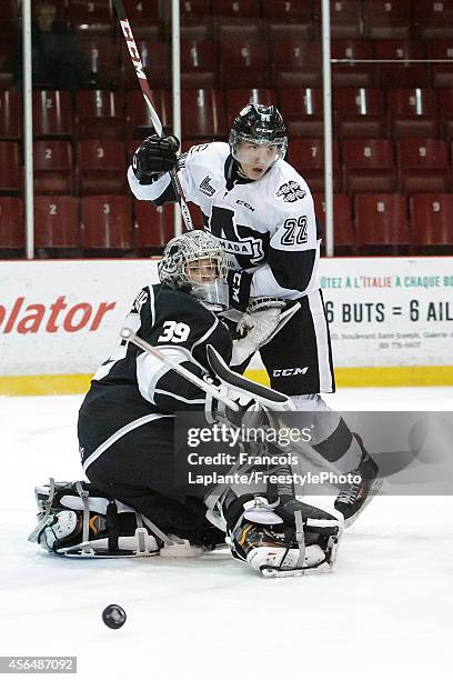 Anthony Brodeur of the Gatineau Olympiques makes a save as Alexander Katerinakis of the Blainville-Boisbriand Armada battles for position on October...