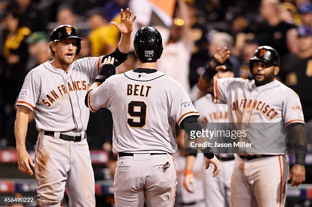 Brandon Belt of the San Francisco Giants is welcomed home as he scores on a four-run home run hit by Brandon Crawford in the fourth inning against...