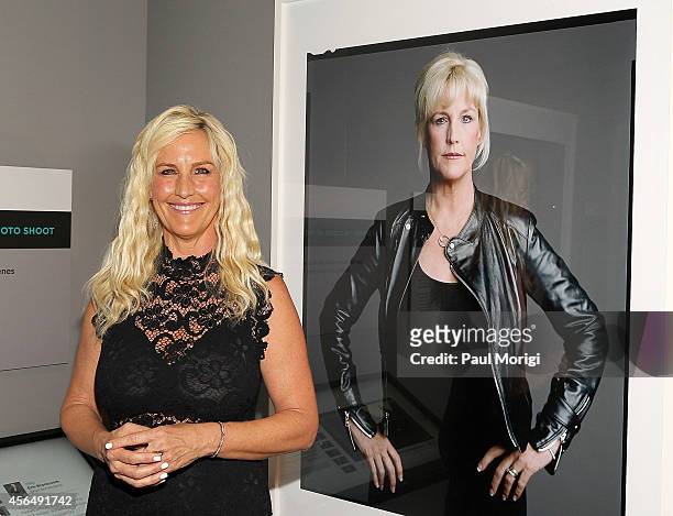 Erin Brockovich poses for a photo next to her portrait at "The Boomer List: Photographs by Timothy Greenfield-Sanders" exhibit at The Newseum on...