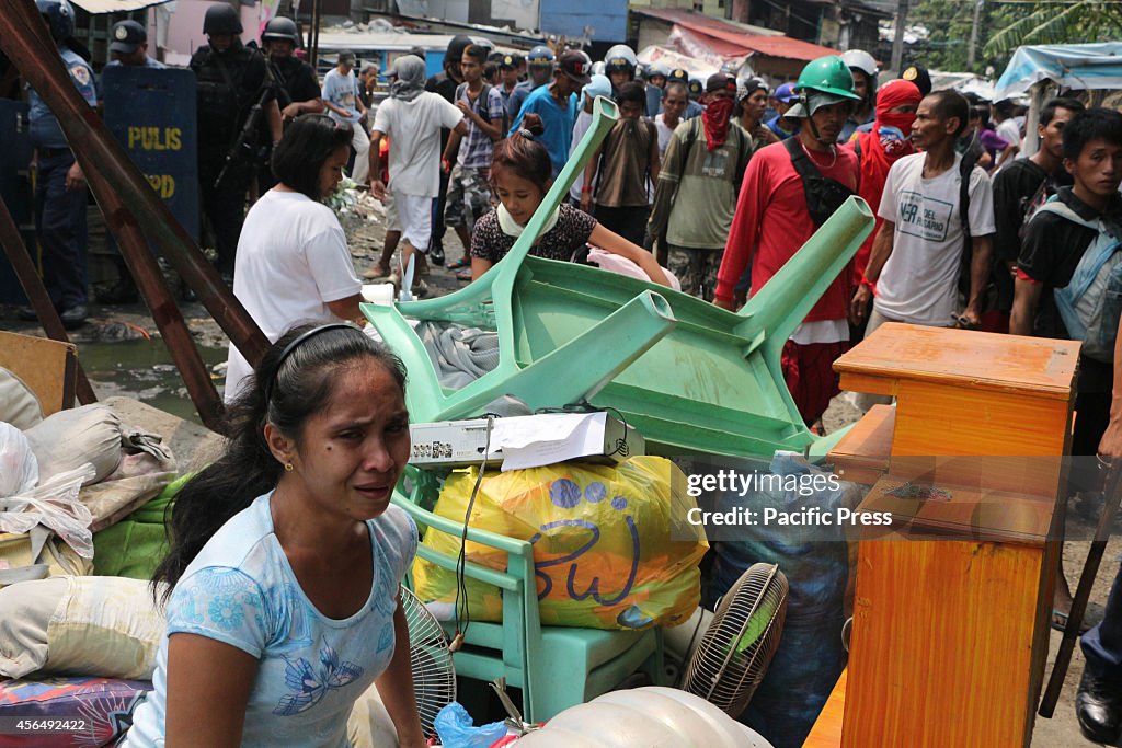 A lady cries while she  guards  their  belongings during the...