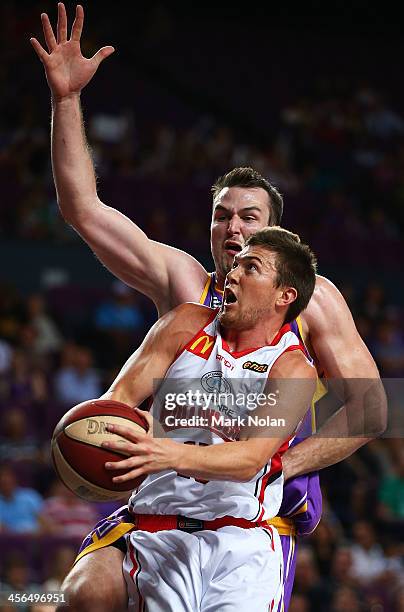 Rotnei Clarke of the Hawks drives to the basket only to be denied by Aj Ogilvy of the Kings during the round 10 NBL match between the Sydney Kings...