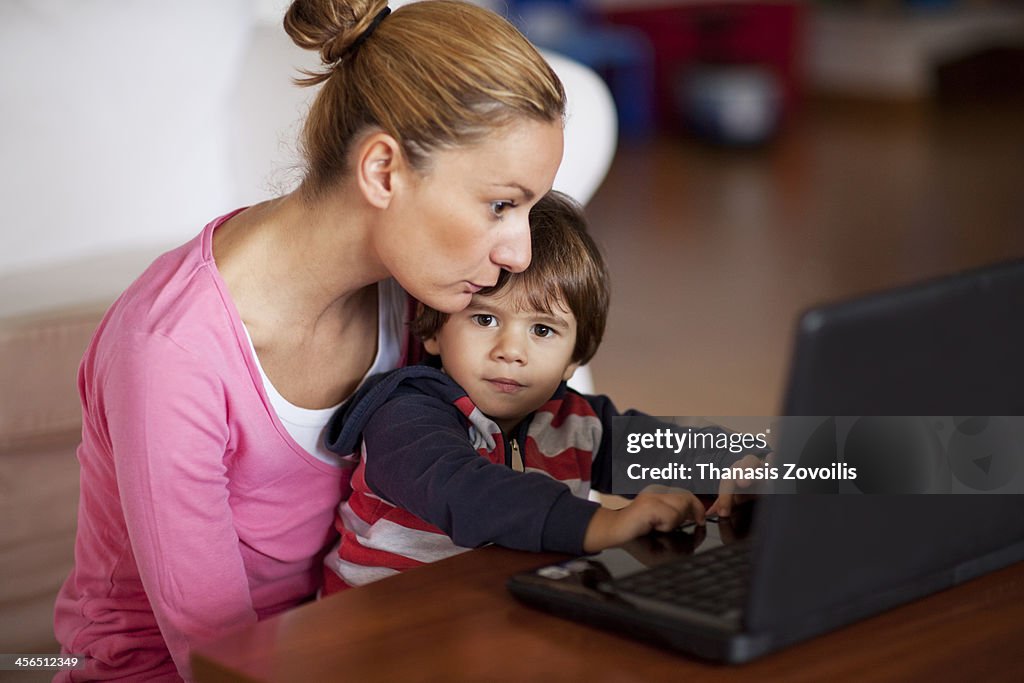 Small boy with his mother using a laptop