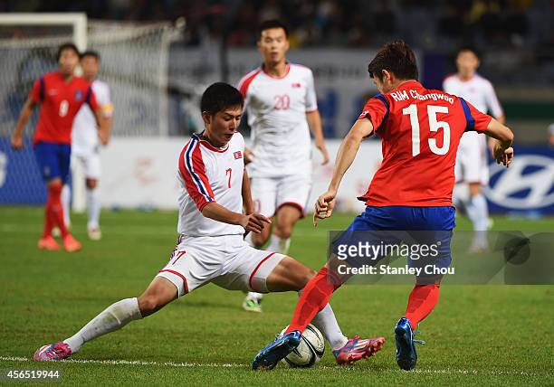 Rim Changwoo of South Korea and Jo Kwang of North Korea compete for the ball during the Football Men's Gold Medal match between South Korea and North...