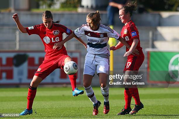 Vivianne Miedema of Muenchen is challenged by Valeria Kleiner and Marina Hegering of Leverkusen during the Allianz Frauen-Bundesliga match between...