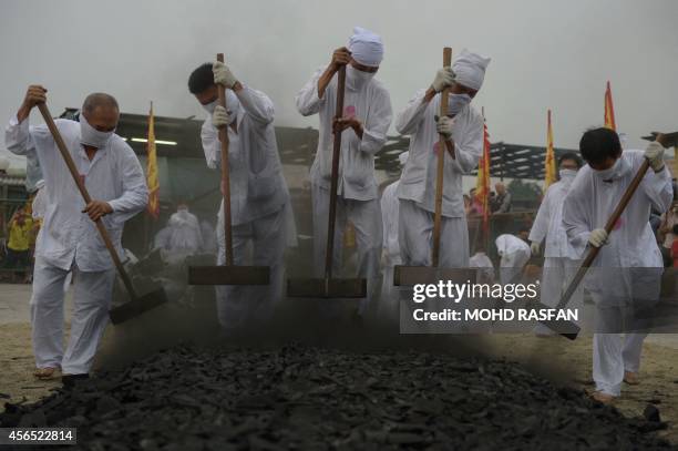 Malaysian Chinese devotees prepare a bed of coals during the climax of the Nine Emperor Gods Festival in Ampang, in the suburbs of Kuala Lumpur on...