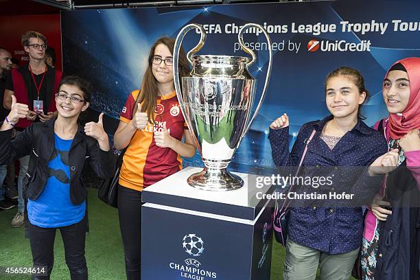 Visitor sieze the opportunity to have their picture taken while standing next to the UEFA Champions League Trophy during the Unicredit UEFA Champions...