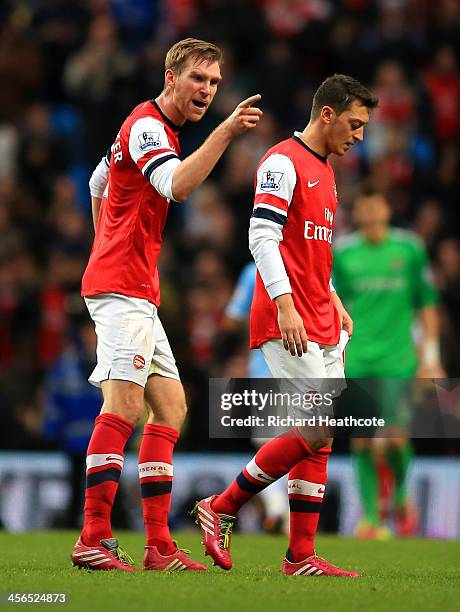 Per Mertesacker of Arsenal has words with Mesut Oezil of Arsenal during the Barclays Premier League match between Manchester City and Arsenal at...
