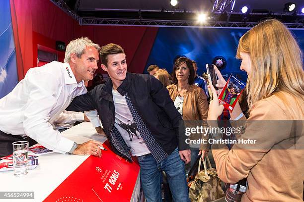 Visitors cease the opportunity to have their picture taken while standing next to UEFA Ambassador Michael Konsel during the UEFA Champions League...