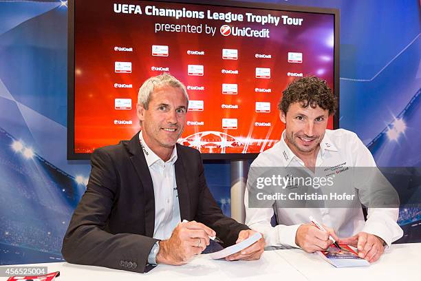 Ambassador Michael Konsel and UEFA Ambassador Mark van Bommel autograph cards for the fans during the Unicredit UEFA Champions League Trophy Tour on...
