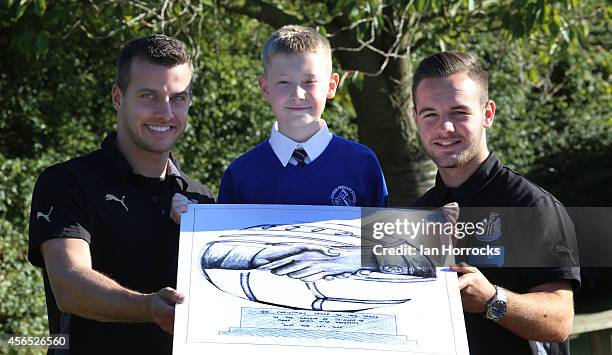 Newcastle United players Steven Taylor and Adam Armstrong with competition winner Spencer Turner during a visit to Farne Primary School as part of...