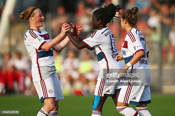 Eunice Beckmann of Muenchen celebrates her team's fourth goal with team mates Melanie Behringer and Laura Feiersinger during the Allianz...