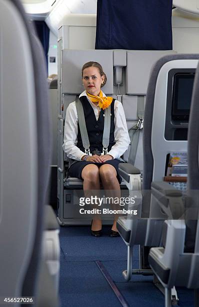 Deutsche Lufthansa AG cabin crew member wears a seat belt during a flight on board a Boeing 747-8 passenger aircraft, manufactured by Boeing Co., as...