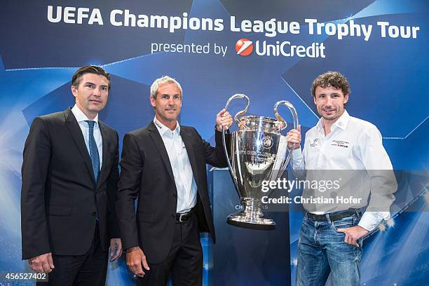 Bank Austria Board Member Robert Zadrazi, UEFA Ambassador Michael Konsel and UEFA Ambassador Mark van Bommel hold the UEFA Champions League Trophy...