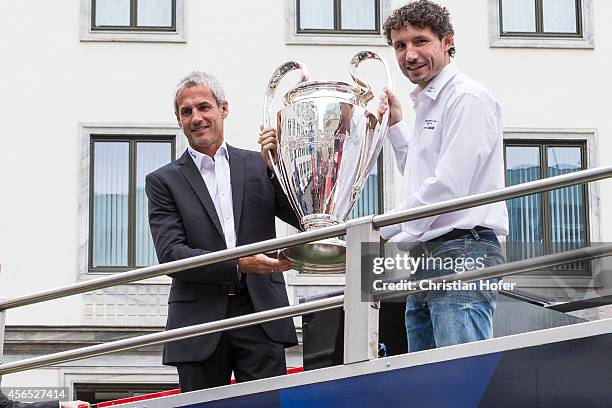 Ambassador Michael Konsel and UEFA Ambassador Mark van Bommel hold the UEFA Champions League Trophy during presentation on October 2, 2014 in Vienna,...