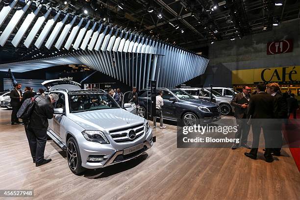 Visitor inspects a Mercedes-Benz GLK G Class automobile on display at the Mercedes-Benz AG stand during the first preview day at the Paris Motor Show...