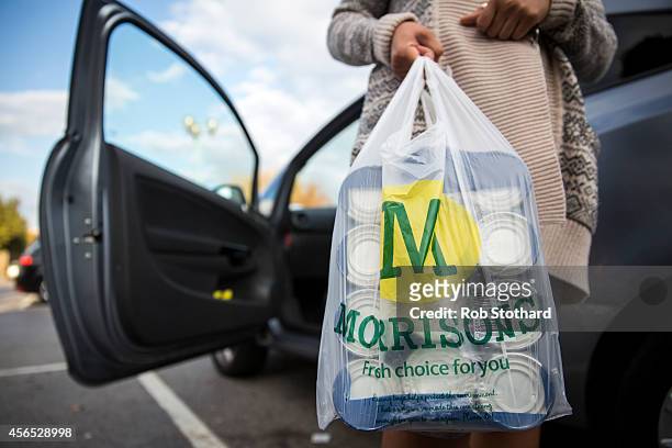 Customer places Morrisons shopping bags in their car on October 2, 2014 in London, England. Morrisons, who reported a fall in half-year profits of...
