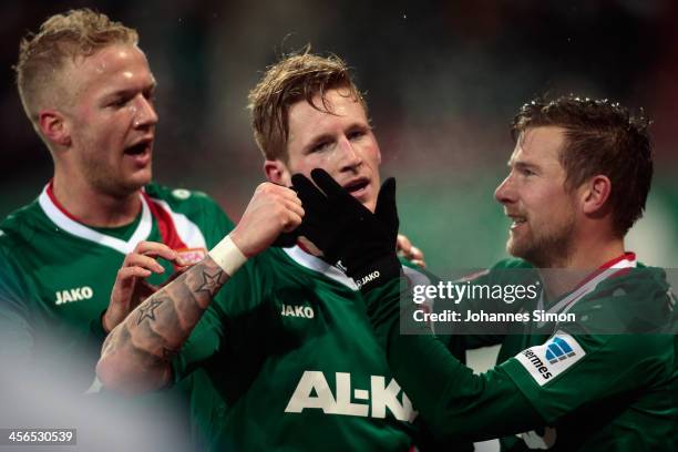 Andre Hahn of Augsburg is congratulated by team-mates Kevin Vogt and Daniel Baier after scoring their team's third goal during the Bundesliga match...