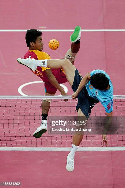 Aung Pyae Tun of Myanmar and Kim Youngman of South Korea challenge for the ball in the Sepaktakraw Men's Regu Semifinal during day thirteen of the...
